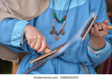 The process of carding wool is an important step in the craft of textile making, requiring skillful hand techniques. - Powered by Shutterstock