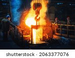 Process of casting in foundry, liquid molten metal pouring in ladle. Heavy metallurgy industry