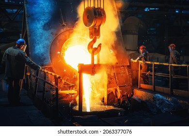 Process of casting in foundry, liquid molten metal pouring in ladle. Heavy metallurgy industry - Shutterstock ID 2063377076