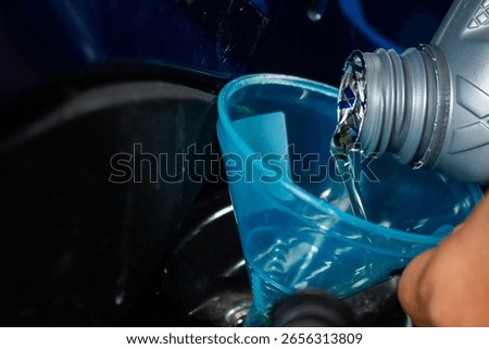 The process of changing engine oil by adding and pouring new, clear, quality engine oil into the motorcycle engine. Engine maintenance system and fuel energy concept.