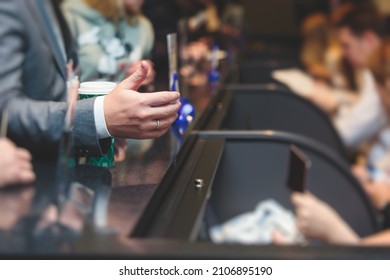 Process of checking in on a conference congress forum event, registration desk table, visitors and attendees receiving a name badge and entrance wristband bracelet and register electronic ticket, 