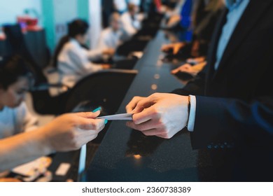 Process of checking in on a conference congress forum event, registration desk table, visitors and attendees receiving a name badge and entrance wristband bracelet and register electronic ticket
 - Powered by Shutterstock