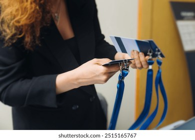 Process of checking in on conference congress forum event, registration desk table, visitors and attendees receiving lanyard with name badge and entry wristband bracelet and register electronic ticket - Powered by Shutterstock