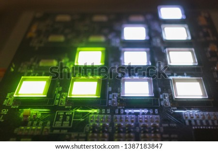 The process of checking several oled displays on the test station. Displays glow brightly of green and white color close up.
