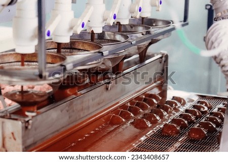 Process of chocolate glazing marshmallows in confectionery on conveyor machine. Marshmallow production line.