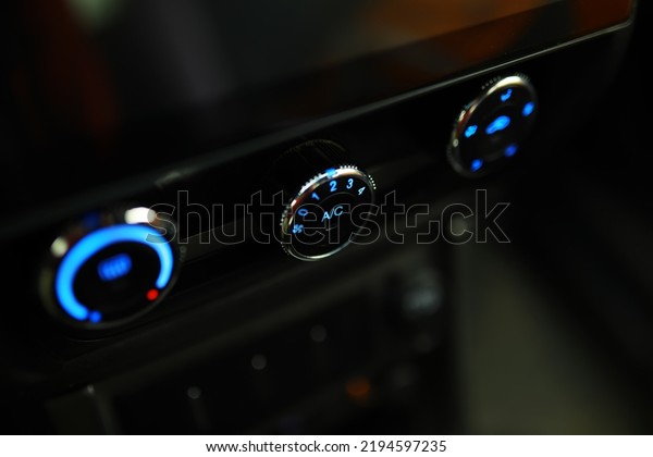 The\
process of choosing climate control in the car. Man regulating\
temperature on car air condition. Modern car\
interior