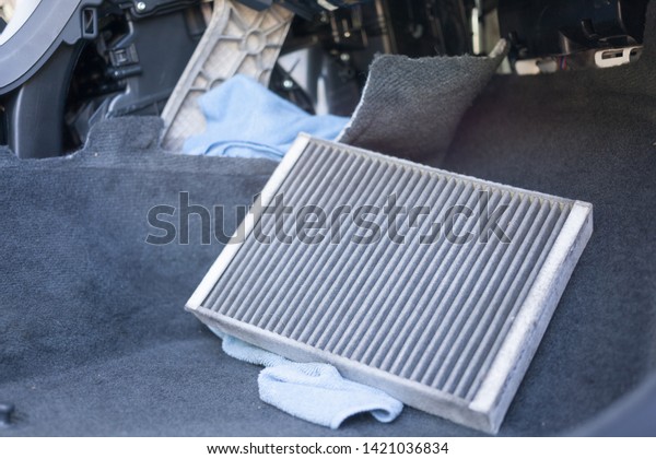 The process of cleaning car air\
conditioning. Dirty air conditioner filter of car.\

