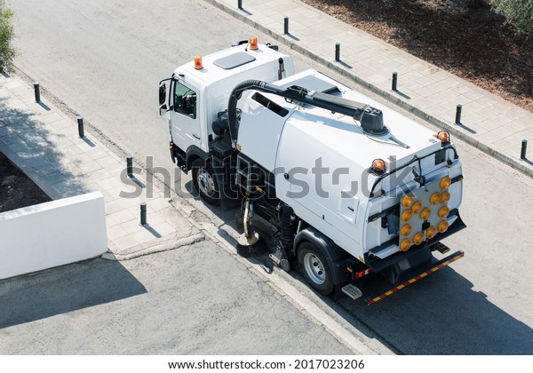 Process of cleaning street with a modern cleaning\
machine. Top view.
