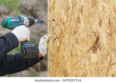 Process Of Construction New And Modern Modular House From Composite Sip Panels. Builder Man Using Electric Drill And Working On Building Development Industry Of Energy Efficient Property