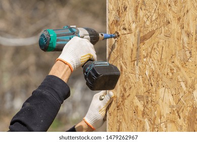 Process Of Construction New And Modern Modular House From Composite Sip Panels. Collar Worker Using Drill And Working On Building Development Industry Of Energy Efficient Property