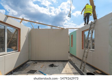 Process Of Construction New And Modern Modular House From Composite Sip Panels. Worker Man In Special Protective Uniform Wear Working On Building Development Industry Of Energy Efficient Property