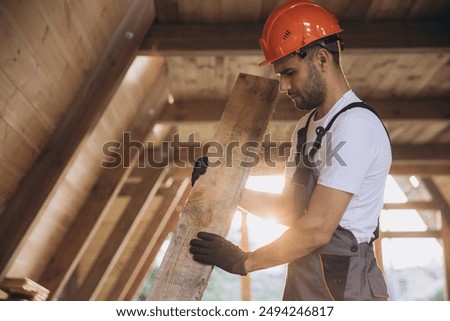 Process of construction new and modern modular house. Worker man in special protective uniform wear working on building development industry of energy efficient property.