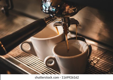 the process of cooking coffee from a professional espresso machine with the help of a triple holder. Preparation of three servings of coffee at the same time
