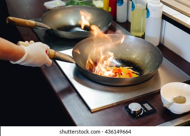 Process Of Cooking On Fire Wok Dish In Deep Pan.