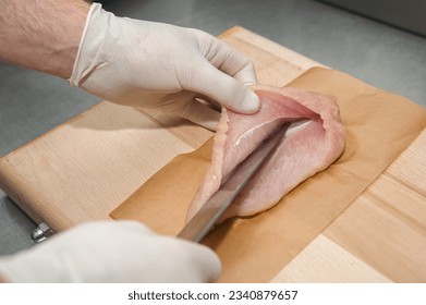 The process of cooking stuffed chicken breast. The chef's hands are cooking chicken. Cutting the breast for stuffing - Powered by Shutterstock