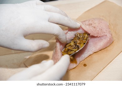 The process of cooking stuffed chicken breast. The chef's hands are cooking chicken. Stuff the breast with a filling of fried mushrooms and leeks
 - Powered by Shutterstock