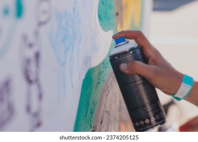 Process of creating graffiti, street artist with aerosol spray paint painting colorful stencil murals on the city walls, equipment set for drawing street art grafiti, paint can, brush and roller - Powered by Shutterstock