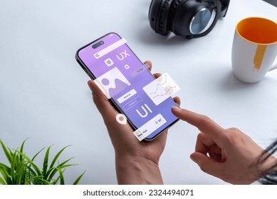 Process of creating an interface for a mobile app. User interface and experience concept. Modern app on smart phone in woman hands - Shutterstock ID 2324494071