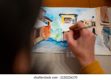 Process of creative art workshop. Artist painting colorful architecture cityscape on paper using brush and watercolors