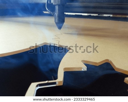 the process of cutting acrylic plastic materials by a laser machine with billowing smoke
 in an industry