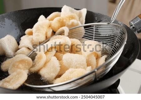 Process Deep Frying Crackers in the Hot Oil, Kitchen Step by Step. Goreng Kerupuk, Indonesian Crackers