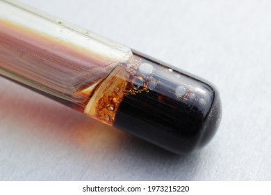 The process of dissolution of iron in nitric acid in a test tube, with the release of brown gas nitrogen dioxide.