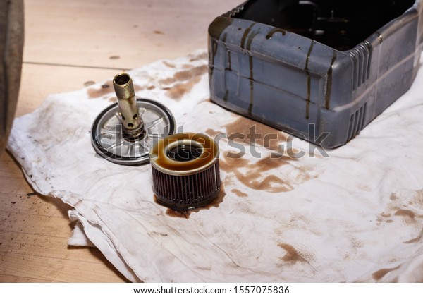 The process of draining oil from a motorcycle\
engine. Engine oil upgrade. Replacing the oil filter in a\
motorcycle engine