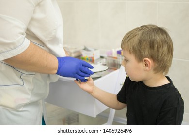 the process of drawing blood from a finger for analysis in a boy