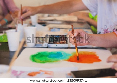 Process of drawing, group class of talented students with painting easels and canvases during lesson of watercolour painting outdoors, drawing class for adult artists in art school 