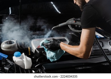 Process of drying car engine after washing with water and chemical detergent. Detailing cleaning motor from dust and dirt