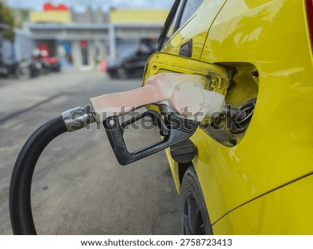 the process of filling a car with fuel using a white pump nozzle, which means using subsidized Pertalite fuel