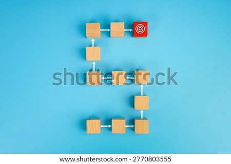 Process flow and goal achievement concept. Wooden blocks connected in a sequence path leading to a target icon, symbolizing planning, workflow, strategy, progress, and successful execution.