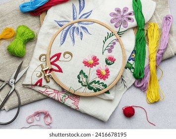 The process of hand embroidering a napkin with colored threads on white fabric. - Powered by Shutterstock