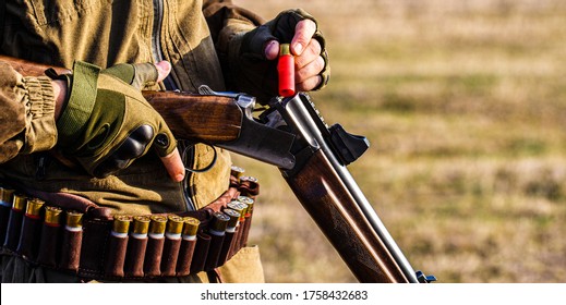 Process of hunting during hunting season. Male hunter in ready to hunt. Closeup. Hunter man. Hunting period. Male with a gun, rifle. Man is charging a hunting rifle. 
