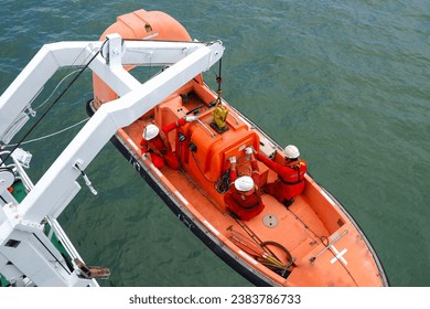 process of launching a rescue boat into the sea, releasing a life boat to perform abandon ship safety drills and man recovery for man overboard drills on board. Davit crane is lowering the life boat
