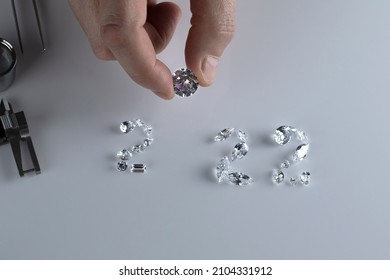 Process Of Laying Out Number 2022 From Diamonds Of Different Sizes And Shapes Using Diamond Dealer Tools. Diamond Expert Workspace With New 2022 Year Top View.