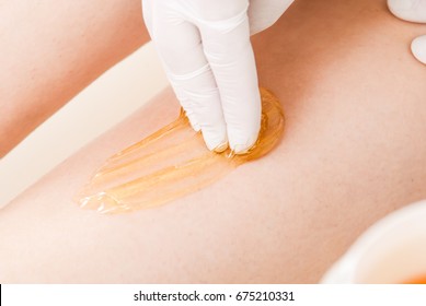 process of legs depilation by sugar for women in beauty salon