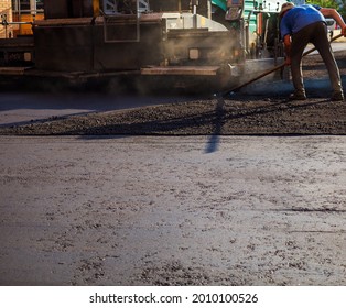 Process of leveling the asphalt manually using a special rake.