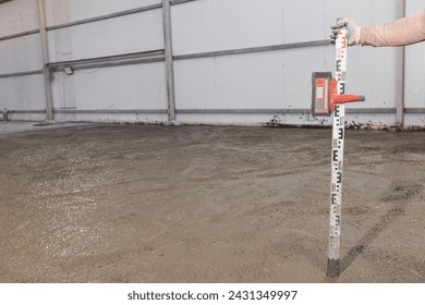 Process leveling floor after pouring cement. Construction site Worker man use laser level for concrete of buildings.