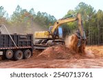Process of loading earth into dump truck using an excavator at construction site
