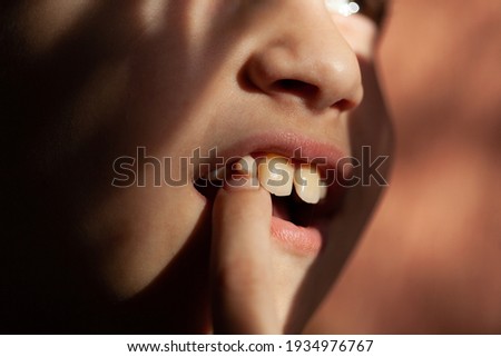 Crop unrecognizable teenage girl eating healthy walnut kernel