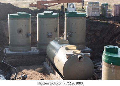 The process of lowering the groundwater level. Big plastic tanks in the pit.