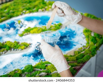 The process of making the art decor of epoxy resin, natural stones and moss