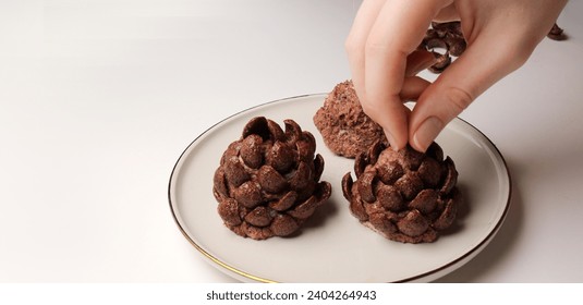 The process of making Christmas tree cone shaped cookies with chocolate flakes, a delightful homemade dessert for the New Year. the girl's hands insert chocolate flakes