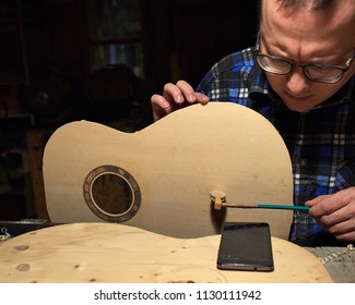 The process of making a classical guitar. Making the right shape of a brace guitar.