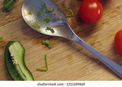 Process Of Making Guacamole - Mexican Avocado Salsa. In This Photo You Can See Some Of Guacamole Ingredients On A Cutting Board. There Are Tomatoes, Chili, Garlic And A Spoon. Macro Photo.