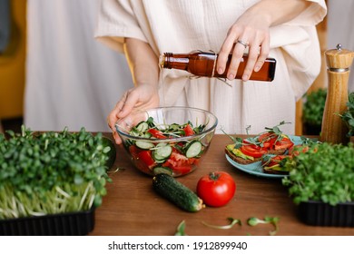 The process of making healthy vegan salad with vegetables and microgreens. hand pours oil on food from reusable bottle. Vegetarian care for health. Nutritionist diet omega-6 vitamins. cold pressed oil