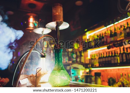 Process of making hookah for smoking. concept of smoking a hookah and having a good time. hookah bowl on the dark background of the bar close up view. Toned image.