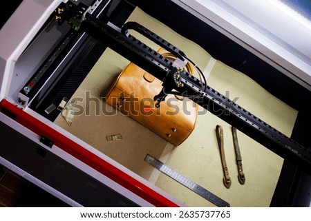 The process of making laser engraving on brown leather bags, perfect for leather industry company profile designs