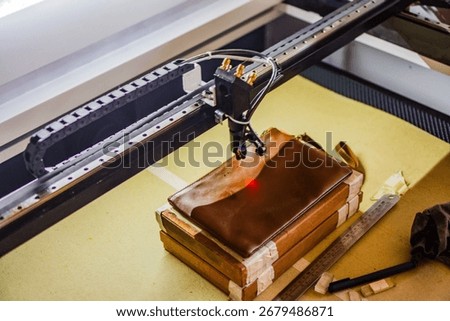 The process of making laser engraving on brown leather bags, perfect for leather industry company profile designs